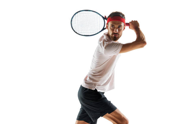 istock Serious and concentrated young man, tennis player during game, standing with racket, ready to hit ball isolated over white background. Sport 1909046604