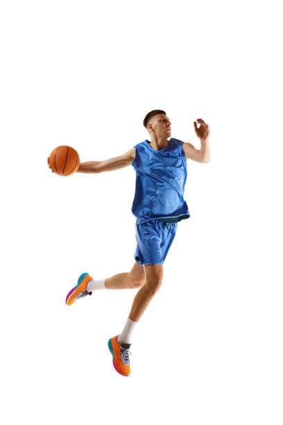 istock Full-length dynamic image of young man, basketball player practicing, playing isolated over white background. Sport concept 1909076747