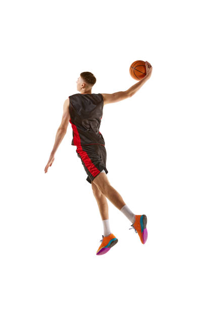 istock Full-length dynamic image of young man, basketball player practicing, playing isolated over white background. Sport concept 1909076880