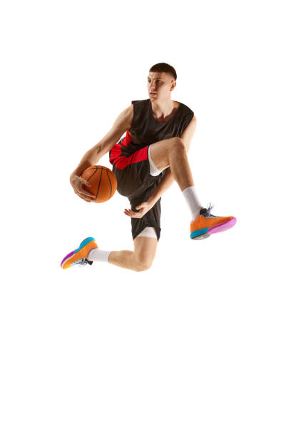 istock Young competitive guy, basketball player in uniform playing, training isolated over white background. Sport concept 1909076927