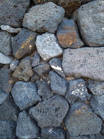 A close-up of the black lava rocks on the beach in the sunshine