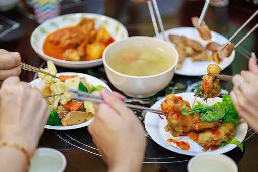 In a close-up view, the Chinese New Year's Eve family reunion dinner unfolds in the dining room, capturing all family members gathered for this special and significant occasion.