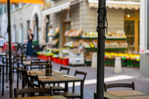 empty table of a restaurant at old town of Riva del Garda in Italy. The background is blurred