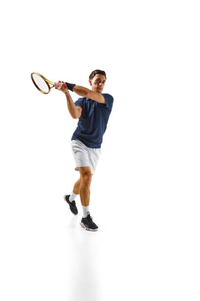 istock Competitive man in his 30s, tennis player in motion, hitting ball with racket, practicing isolated over white background 1909094964