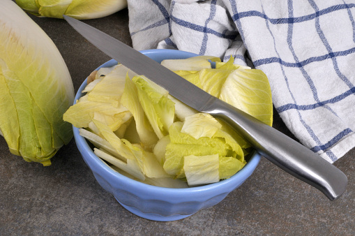 Bowl of endives cut with a knife close-up