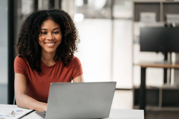 istock Business woman using laptop computer writing business plan while sitting in office. 1909116555