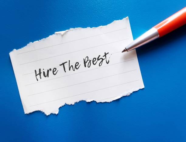 istock Orange pen on blue background writing on paper note HIRE THE BEST, means business owner needs to hire the top talent in their field for future success 1909131469