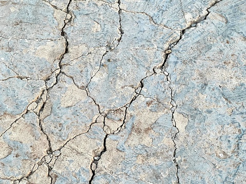 a photography of a cracky surface with a small hole in the middle.