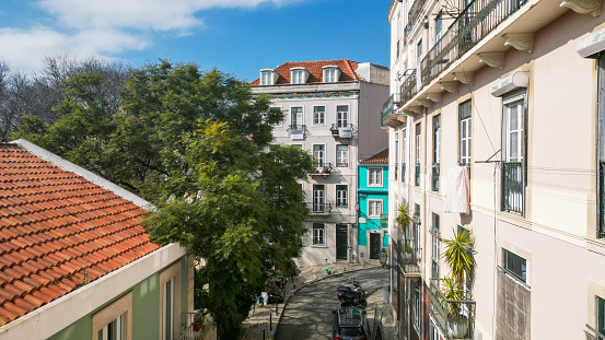 A traditional quaint cobbled street, lined with traditional buildings and quaint storefronts, Lisbon, Portugal