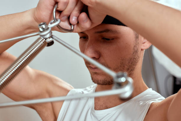 istock A man does exercises for the neck on reformers during Pilates, a young man shows exercises for the cervical spine during Pilates on reformers. 1909167110