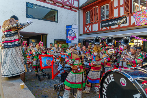 Lucerne, Switzerland - February 20, 2023: Band of musicians in costumes play to the crowd, part of the Fasnacht Carnival, in Lucerne (Luzern), Switzerland