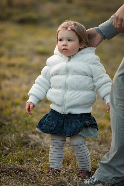 istock Child's tentative steps guided by parental hand 1909190145
