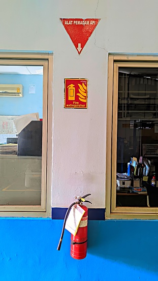 A light fire extinguisher is installed on the wall of a building as a safety device when a fire occurs