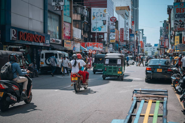 Crowds and businesses on the streets of Colombo, Sri Lanka. Colombo, Sri Lanka -November 20, 2023:
A busy scene with people riding through the old part of the city on a three wheels vehicle and a motorcycles in Sri Lanka's capital, Colombo. taxi sri lanka stock pictures, royalty-free photos & images