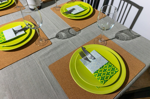 Vibrant green-themed table setting with origami-folded napkins in a cozy living room ambiance.