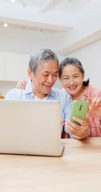 istock old couple look laptop and phone 1909223262