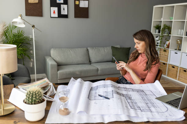 istock Female designer in office working on architects project. 1909231411