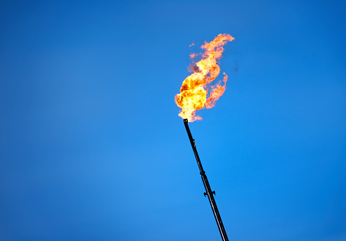 A flaring stack at an oil refinery releasing burning gas into the atmosphere