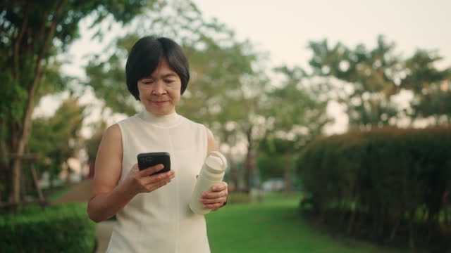 Asian woman using smartphone in the park.