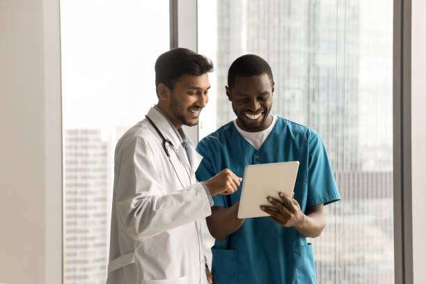 istock Two happy diverse doctors using tablet for healthcare discussion 1909302862