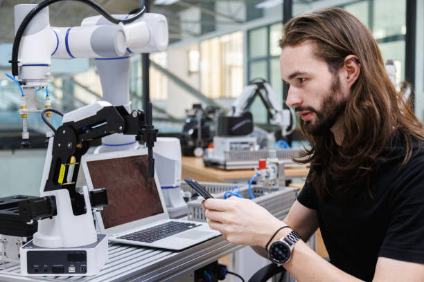 automation machine engineer student study and inspection controlling robot machine by mobile phone application in university workshop. ai robot innovation technology in industry 5.0 estudiante de ingeniería de máquinas de automatización estudia e inspecciona la máquina robótica de control mediante una aplicación de teléfono móvil en el taller de la universidad. tecnología de innovación robótica de ia en la industria 5.0
