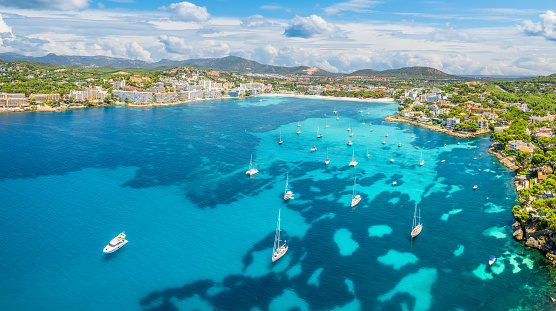 Captivating aerial shot of Cala de Santa Ponça azure waters, with its expansive sandy beach and lush surroundings, a tranquil family-friendly haven, Mallorca.