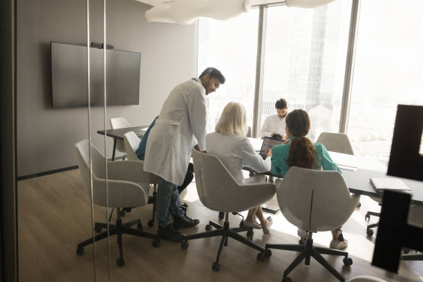 el equipo de médicos de la clínica discute el trabajo del hospital y el proceso comercial - exam business caucasian board room fotografías e imágenes de stock