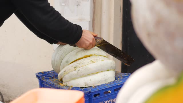 men cutting pumpkin in half