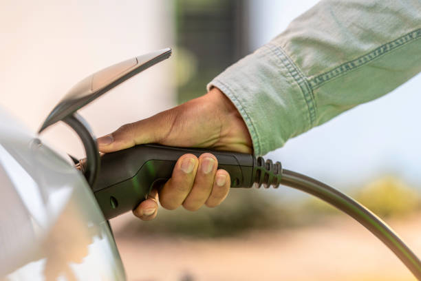 istock Man holding an electric car charger 1909353220
