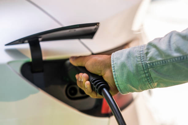 istock Man holding an electric car charger 1909353221