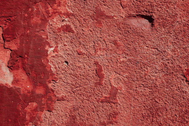istock Red concrete wall with deep scratches and chips. Various variations of abrasions. 1909355299
