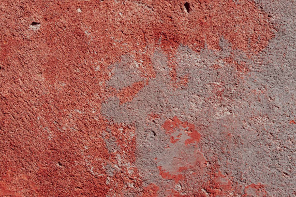 istock Red concrete wall with deep scratches and chips. Various variations of abrasions. 1909361000