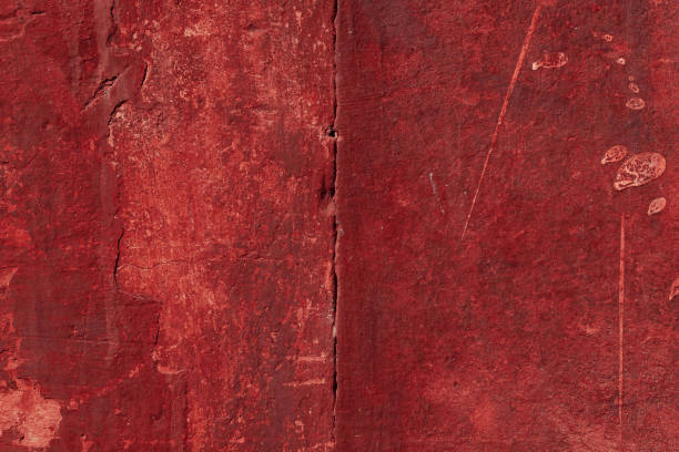 istock Red concrete wall with deep scratches and chips. Various variations of abrasions. 1909365768