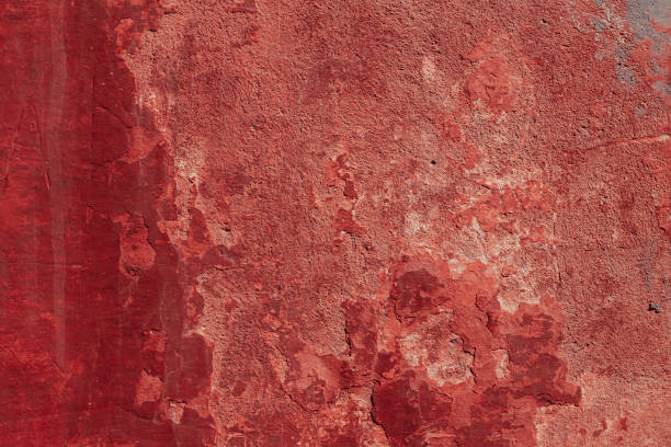 istock Red concrete wall with deep scratches and chips. Various variations of abrasions. 1909371042