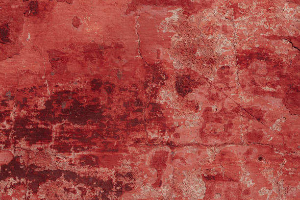 istock Red concrete wall with deep scratches and chips. Various variations of abrasions. 1909378343