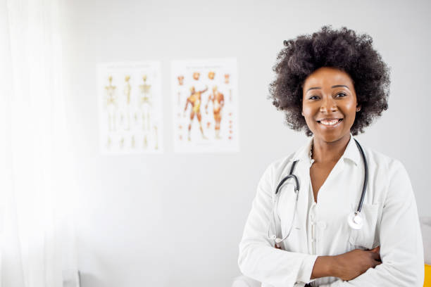 istock Woman hospital worker looking at camera and smiling, office, grey background 1909383110