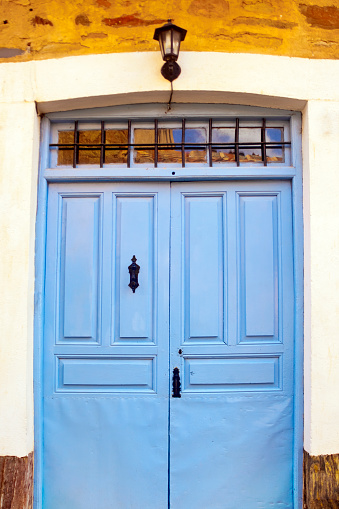 Traditional wooden door painted blue , stone house . Old village street in  Castrillo de los Polvazares, León, Castilla y León, Spain.