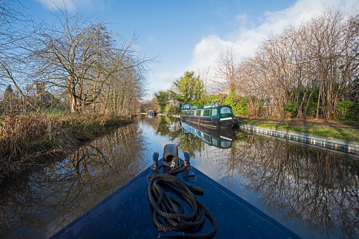 View from a narrowboat travelling in English rural countryside scenery on British waterway canal