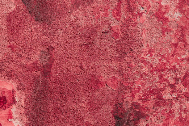 istock Red concrete wall with deep scratches and chips. Various variations of abrasions. 1909387288