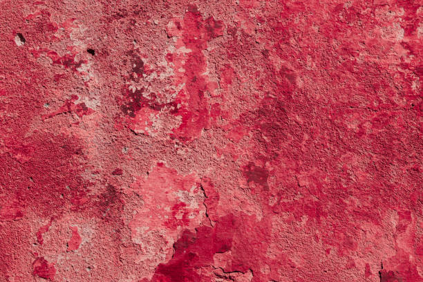 istock Red concrete wall with deep scratches and chips. Various variations of abrasions. 1909390947