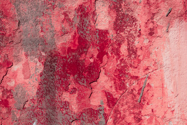 istock Red concrete wall with deep scratches and chips. Various variations of abrasions. 1909400350