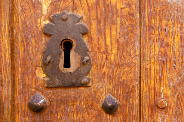 istock Traditional  ancient wooden door, cast iron key hole. 1909406078