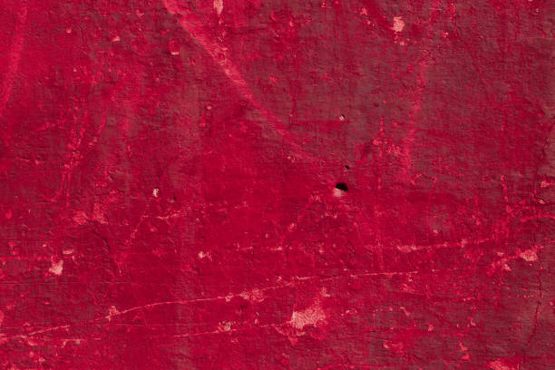 istock Red concrete wall with deep scratches and chips. Various variations of abrasions. 1909421400