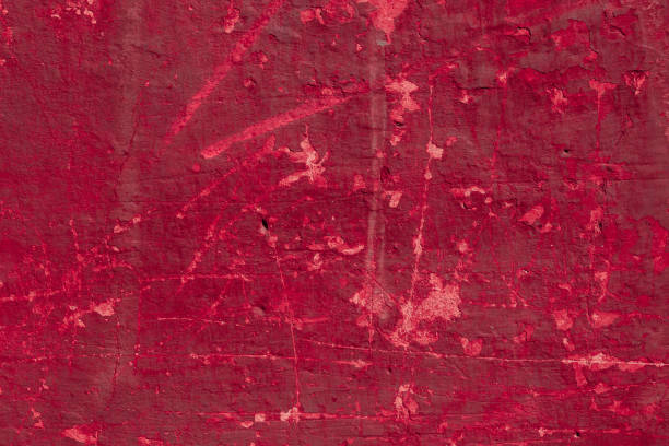 istock Red concrete wall with deep scratches and chips. Various variations of abrasions. 1909421401