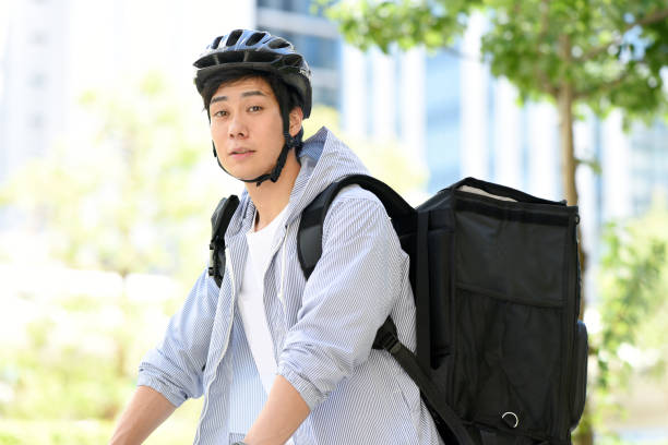 istock Young Asian man with backpack and providing delivery service on bicycle 1909425089