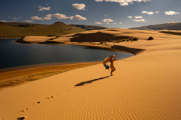 Woman walks in oasis and sandy dunes