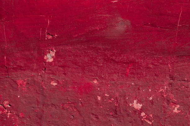Red concrete wall with deep scratches and chips. Various variations of abrasions.
