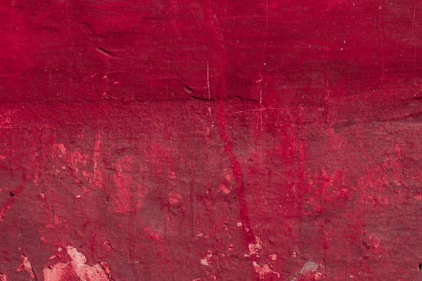 istock Red concrete wall with deep scratches and chips. Various variations of abrasions. 1909441249