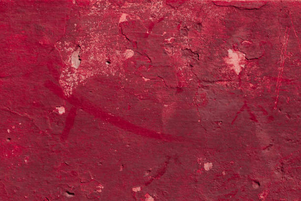 istock Red concrete wall with deep scratches and chips. Various variations of abrasions. 1909442891
