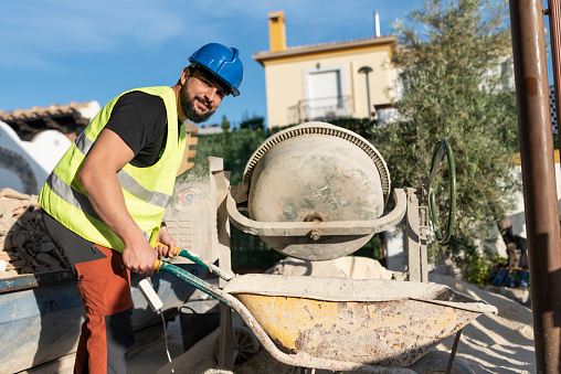 40-year-old construction worker renovating a house using concrete mixer